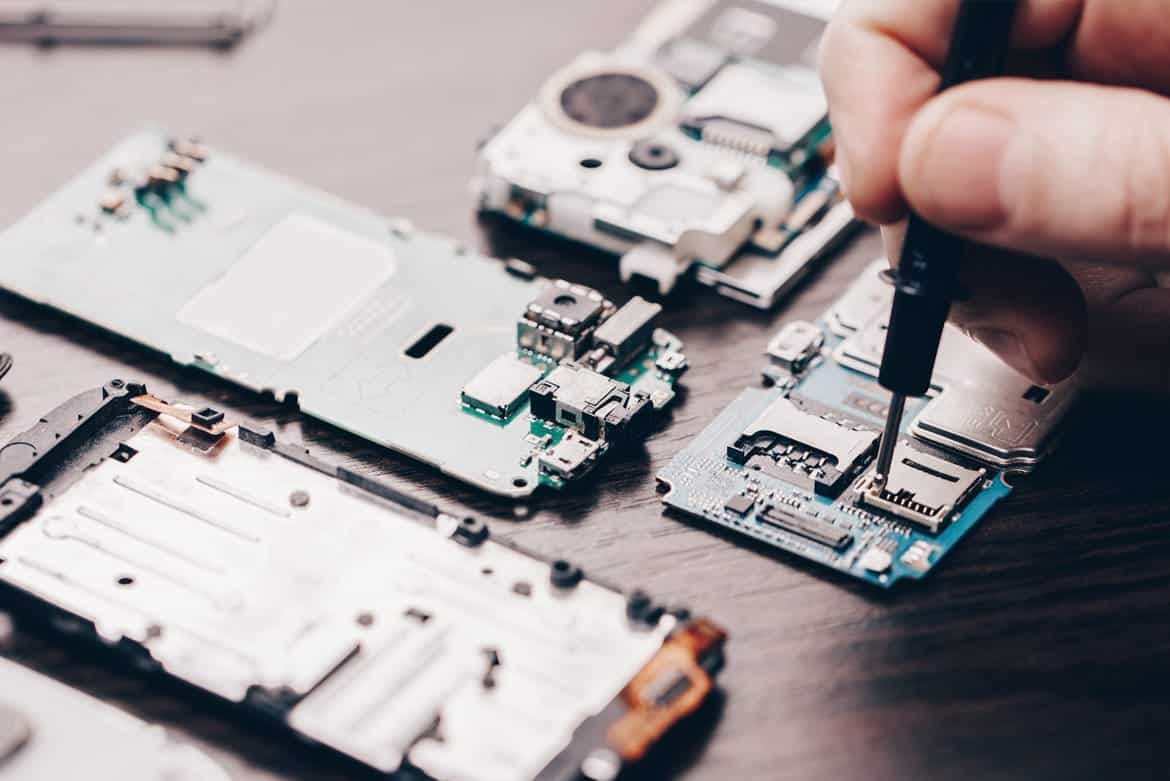 Technician repairing a smartphone on a workbench